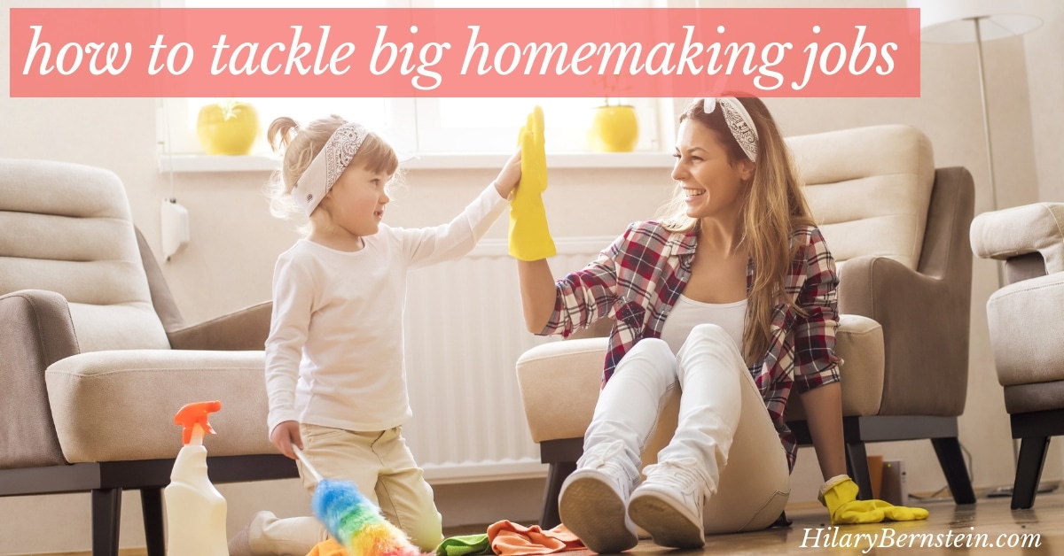 Mom and daughter sit on the floor with cleaning supplies