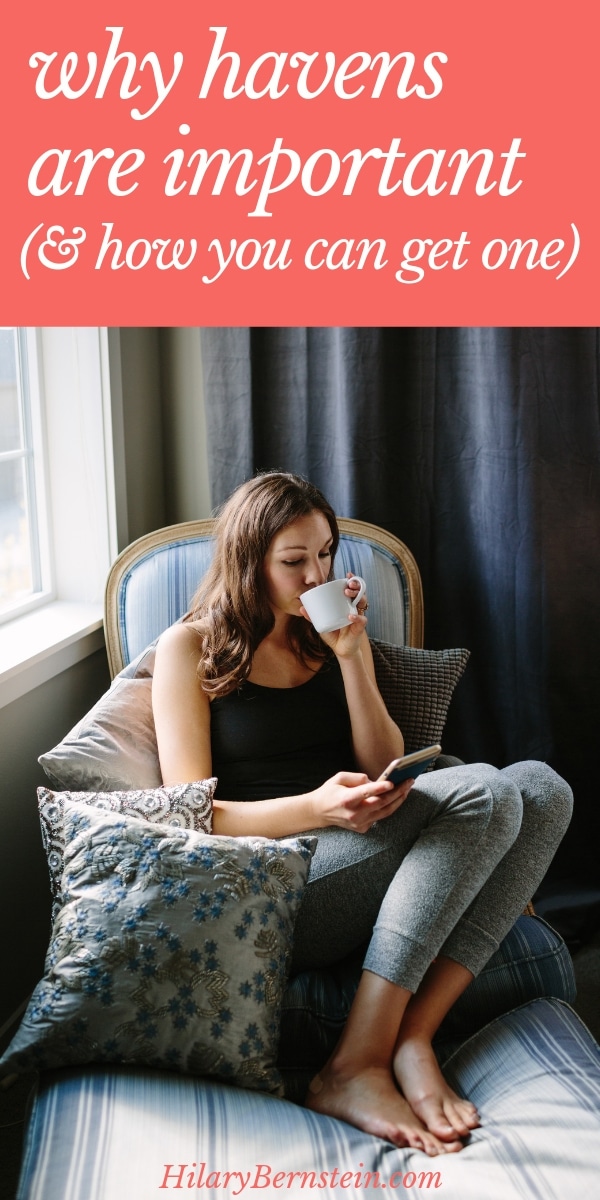 Woman sits on a chair with pillows, a smart phone, and a cup of tea