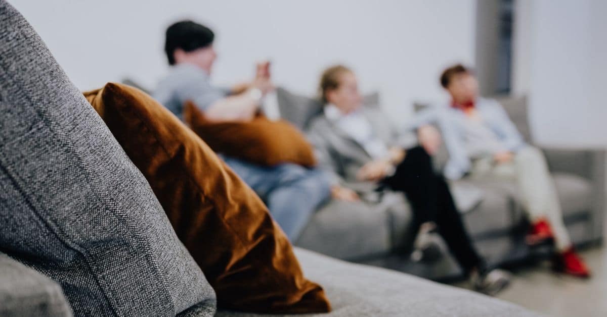 Friends sit on a couch and visit