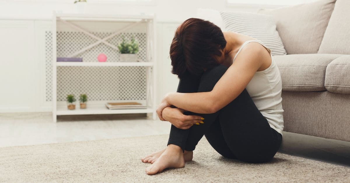 Woman sits on floor